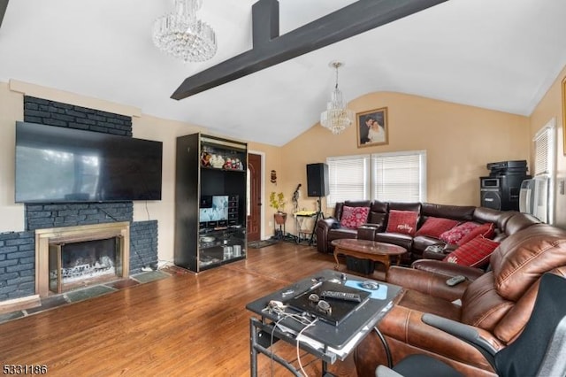 living room featuring hardwood / wood-style flooring, vaulted ceiling with beams, a fireplace, and a chandelier