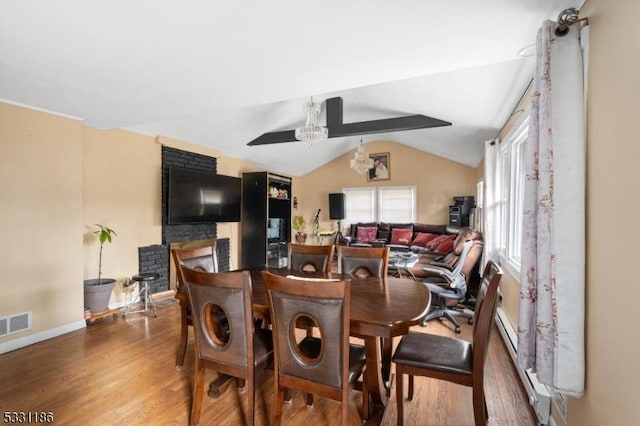 dining space with vaulted ceiling with beams, a chandelier, and wood-type flooring