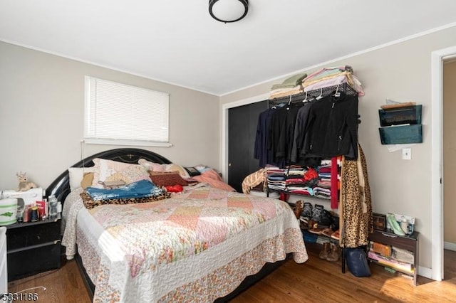 bedroom with wood-type flooring and ornamental molding