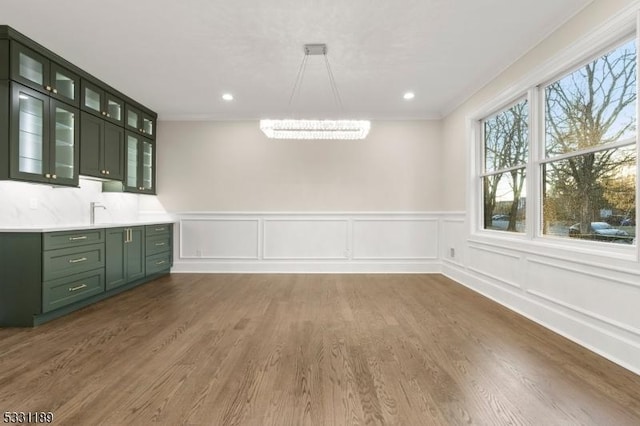 unfurnished dining area featuring dark wood finished floors, crown molding, and recessed lighting