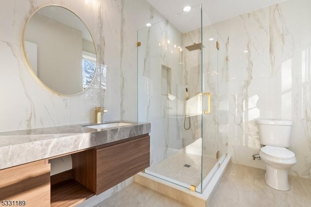 full bath with toilet, a marble finish shower, tile walls, and vanity