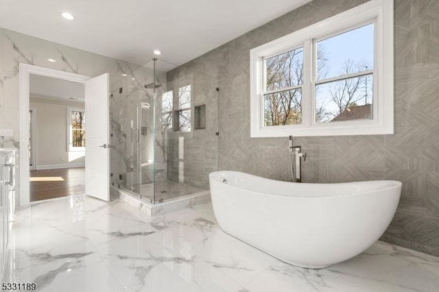 bathroom featuring stone wall, recessed lighting, marble finish floor, a soaking tub, and a marble finish shower