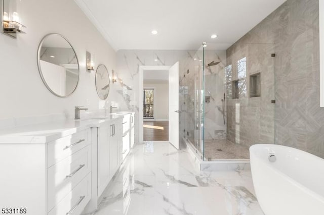 bathroom featuring double vanity, marble finish floor, a freestanding tub, and a marble finish shower