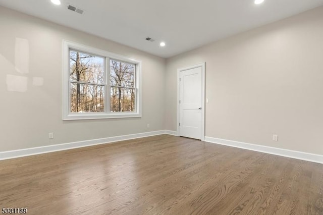 unfurnished room featuring visible vents, baseboards, dark wood finished floors, and recessed lighting