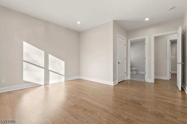 unfurnished room with recessed lighting, baseboards, and wood finished floors