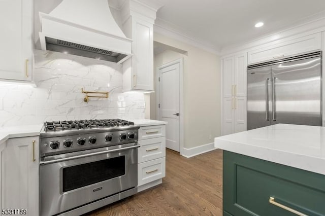 kitchen with premium range hood, high quality appliances, and white cabinets