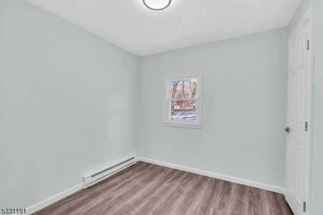 spare room featuring hardwood / wood-style flooring and a baseboard radiator