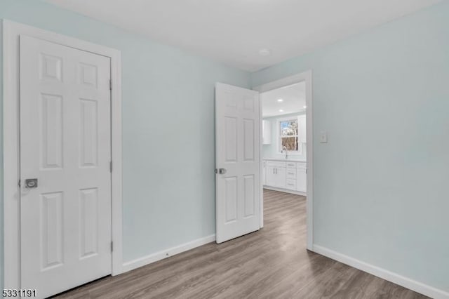 unfurnished bedroom featuring light hardwood / wood-style floors and sink