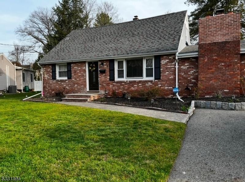 view of front of property with a front yard and central air condition unit