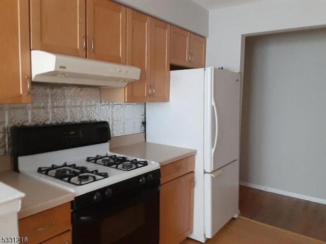 kitchen with decorative backsplash and white appliances