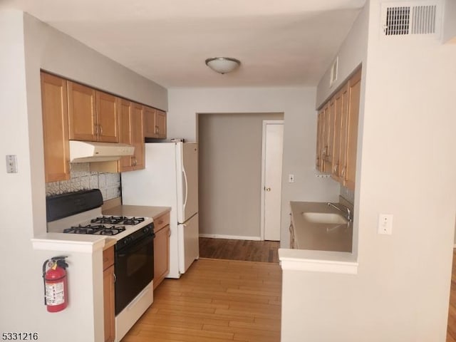 kitchen featuring decorative backsplash, light hardwood / wood-style floors, sink, and white range with gas cooktop