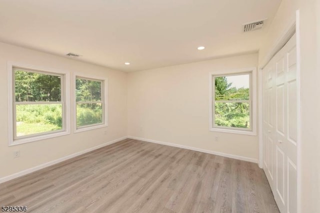 empty room featuring light hardwood / wood-style floors and plenty of natural light