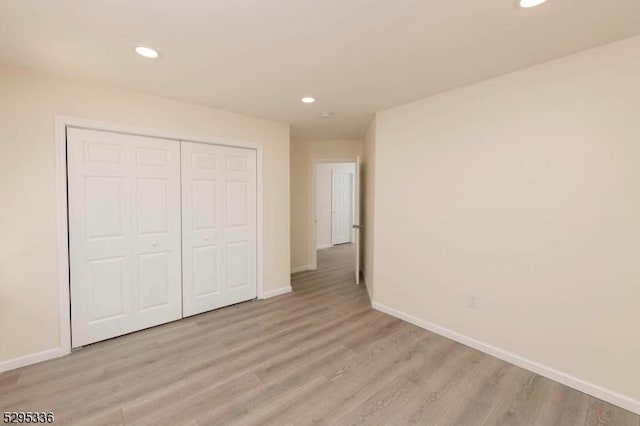 unfurnished bedroom with a closet and light wood-type flooring