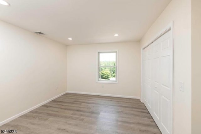 unfurnished bedroom featuring a closet and light hardwood / wood-style flooring