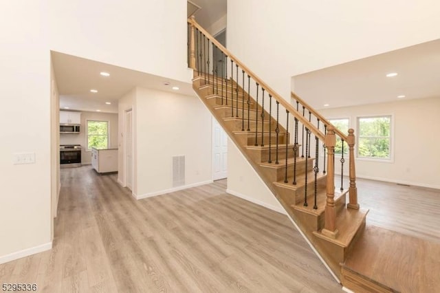 stairs with a healthy amount of sunlight and wood-type flooring