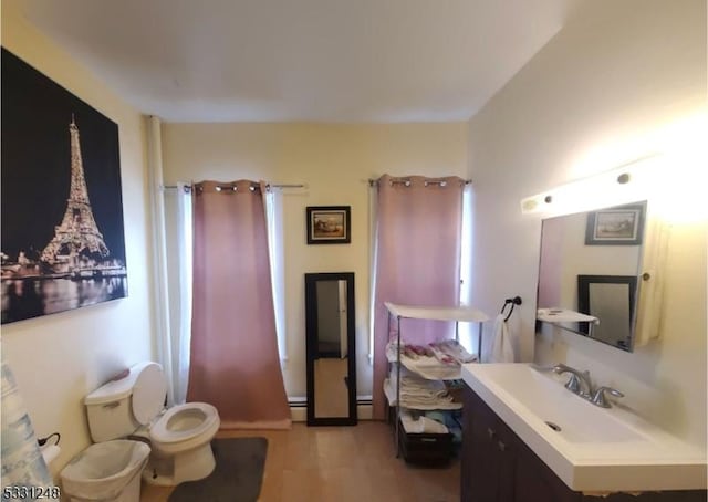 bathroom with vanity, a baseboard radiator, and toilet