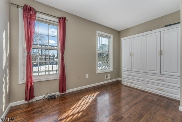 unfurnished bedroom with dark hardwood / wood-style flooring