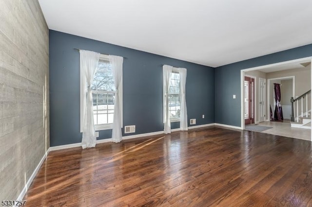 spare room featuring dark hardwood / wood-style flooring and plenty of natural light