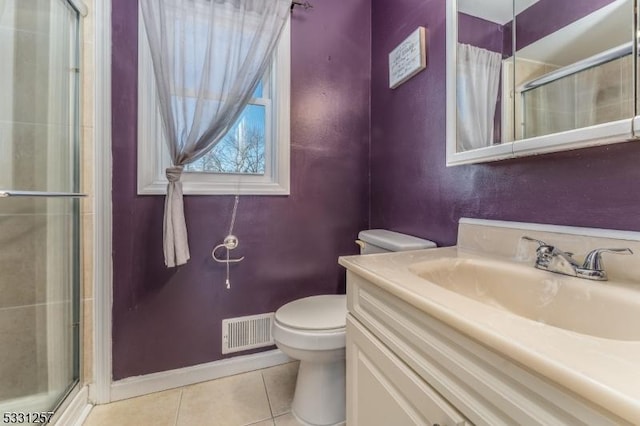 bathroom with tile patterned flooring, vanity, toilet, and an enclosed shower