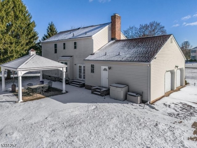 rear view of property featuring french doors and a garage