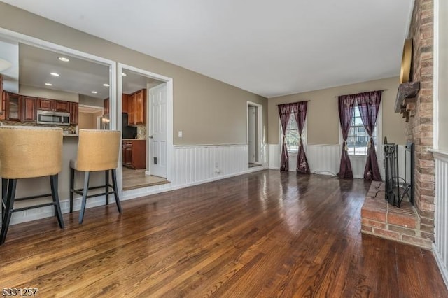 living room with hardwood / wood-style flooring and a brick fireplace