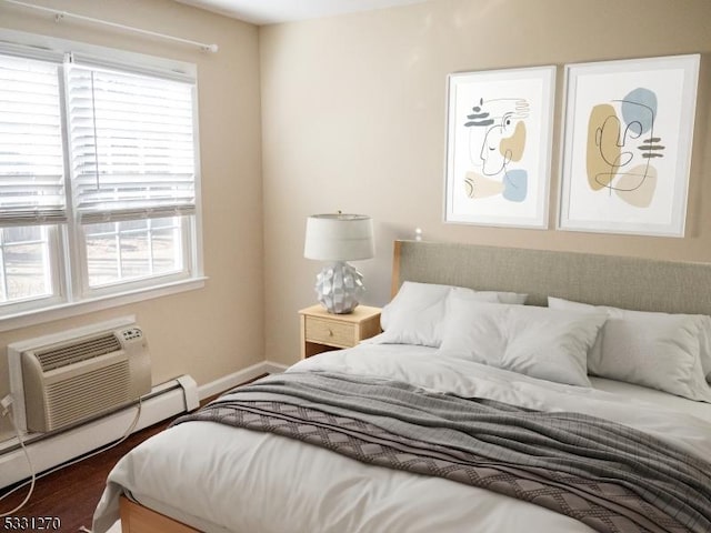 bedroom with a baseboard radiator, dark hardwood / wood-style floors, and an AC wall unit