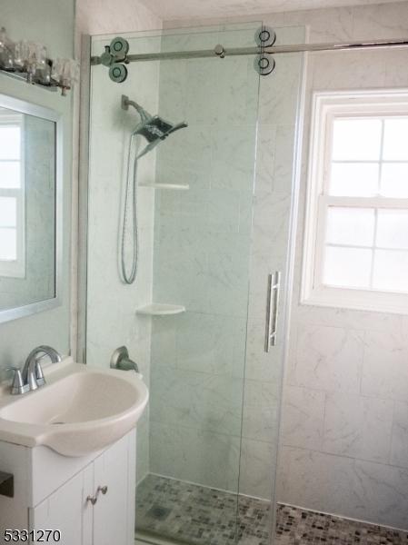 bathroom featuring an enclosed shower and vanity