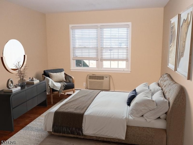 bedroom featuring a wall mounted AC and dark hardwood / wood-style floors