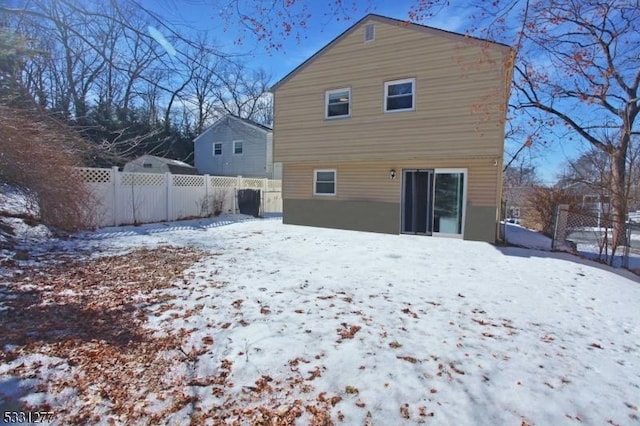 view of snow covered rear of property