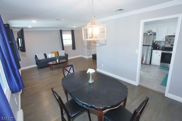 dining area featuring ornamental molding and dark hardwood / wood-style flooring