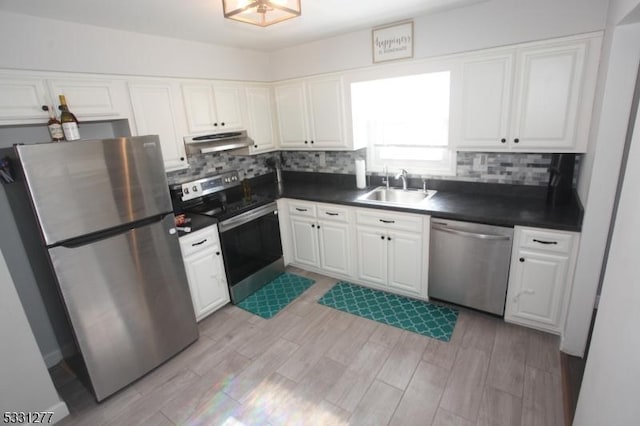 kitchen featuring sink, light wood-type flooring, white cabinetry, stainless steel appliances, and decorative backsplash