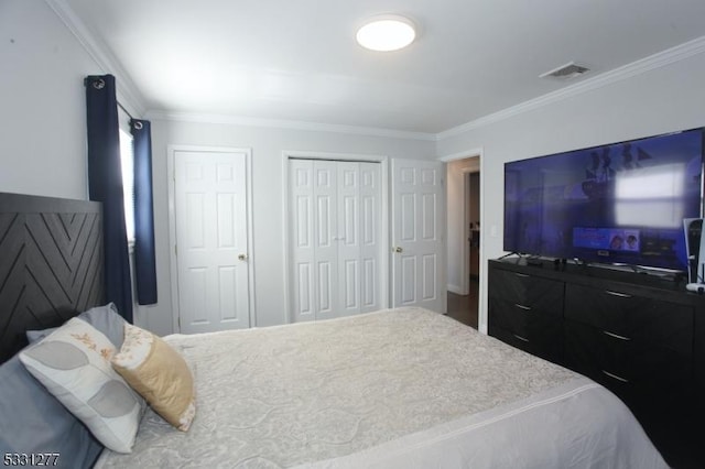 bedroom with two closets and crown molding