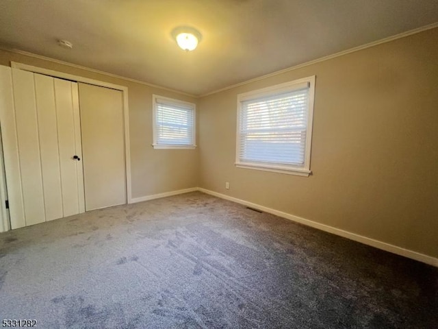 unfurnished bedroom with carpet, a closet, and crown molding