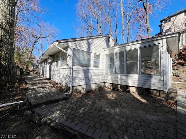 view of home's exterior with a sunroom