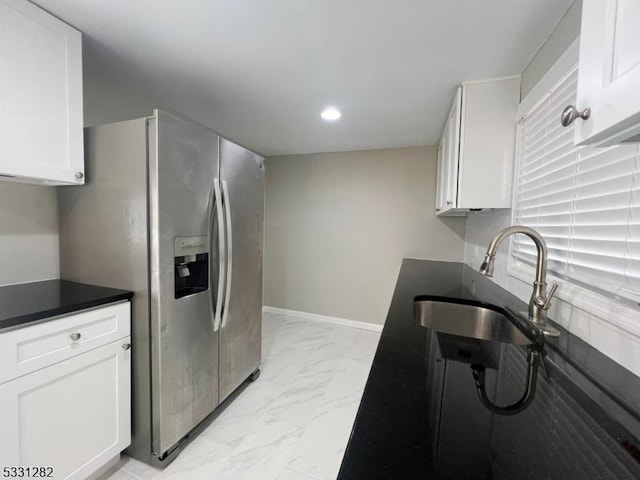 kitchen with stainless steel fridge with ice dispenser, white cabinetry, and sink