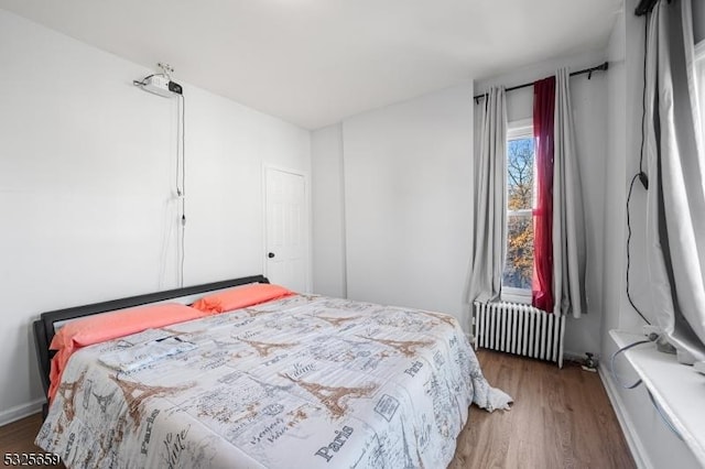 bedroom featuring dark hardwood / wood-style flooring and radiator