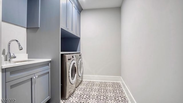 clothes washing area featuring light tile patterned flooring, cabinets, sink, and washer and clothes dryer