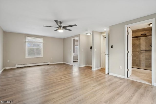 interior space with ceiling fan, baseboard heating, ensuite bathroom, and light wood-type flooring