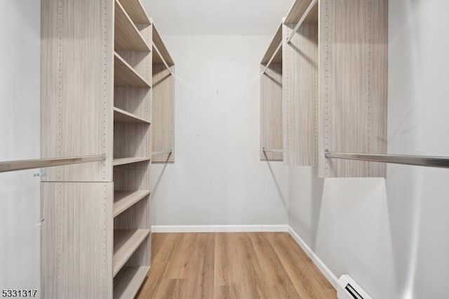 walk in closet featuring wood-type flooring and a baseboard radiator