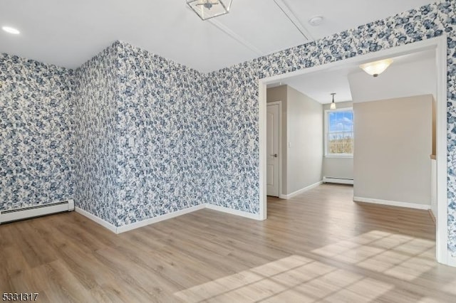 spare room featuring hardwood / wood-style flooring and a baseboard radiator