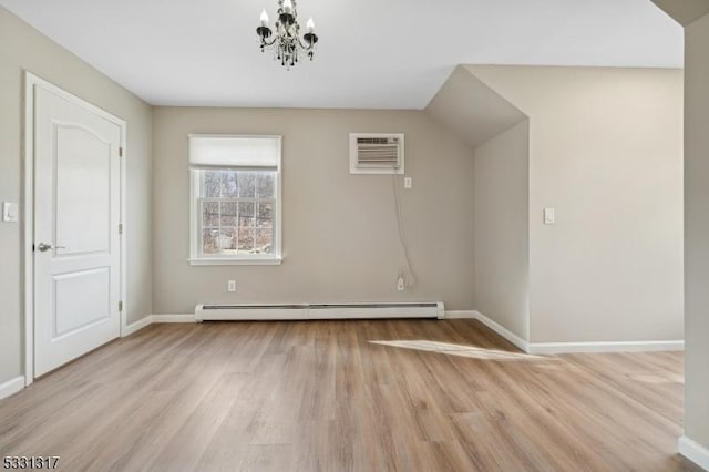 additional living space featuring baseboard heating, light hardwood / wood-style flooring, a wall mounted AC, and an inviting chandelier