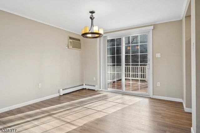 empty room featuring baseboard heating, hardwood / wood-style floors, a wall unit AC, and a notable chandelier