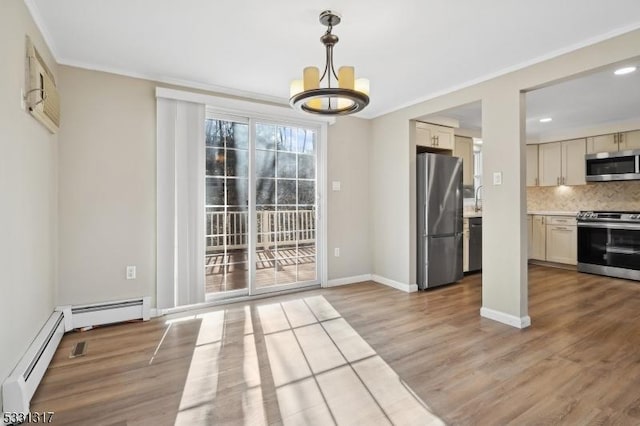 interior space featuring crown molding, a baseboard heating unit, an inviting chandelier, and hardwood / wood-style flooring