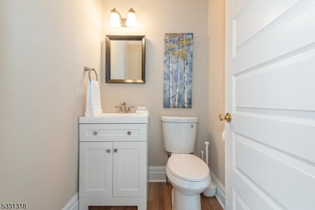 bathroom featuring vanity, wood-type flooring, and toilet