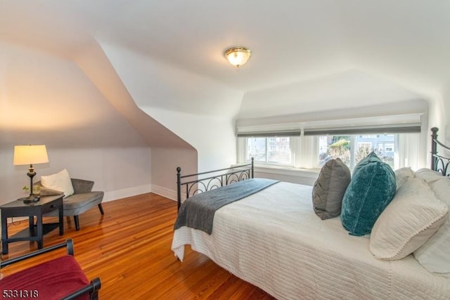 bedroom featuring hardwood / wood-style flooring and vaulted ceiling