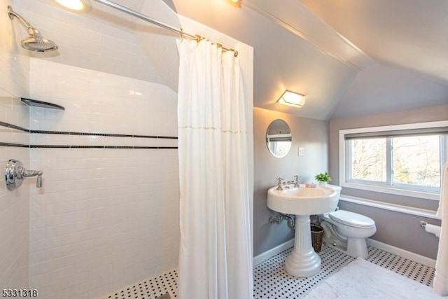 bathroom featuring a shower with curtain, toilet, and lofted ceiling