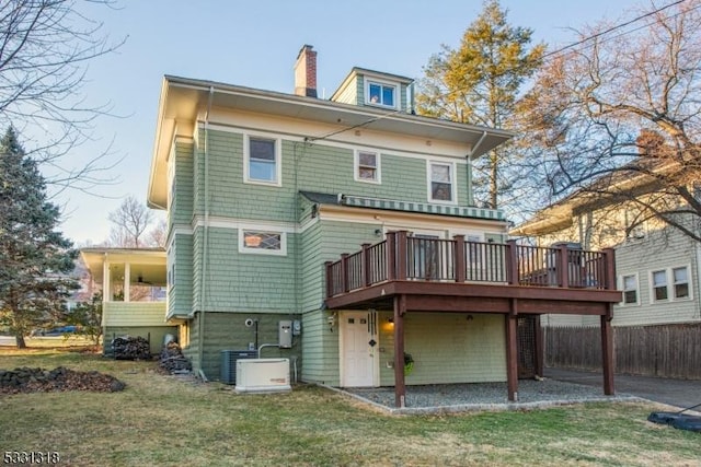 back of house with a lawn and a deck