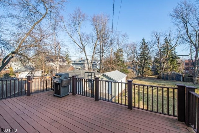 wooden deck with a yard and grilling area