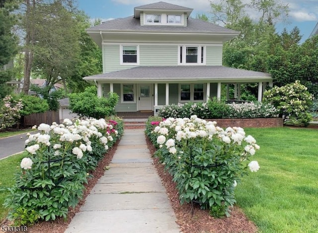 farmhouse with a porch and a front lawn