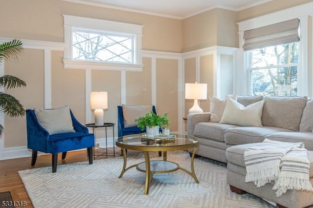 living room with ornamental molding, light hardwood / wood-style flooring, and a healthy amount of sunlight